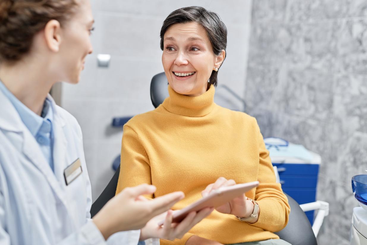 Patient smiling and talking to dentist.