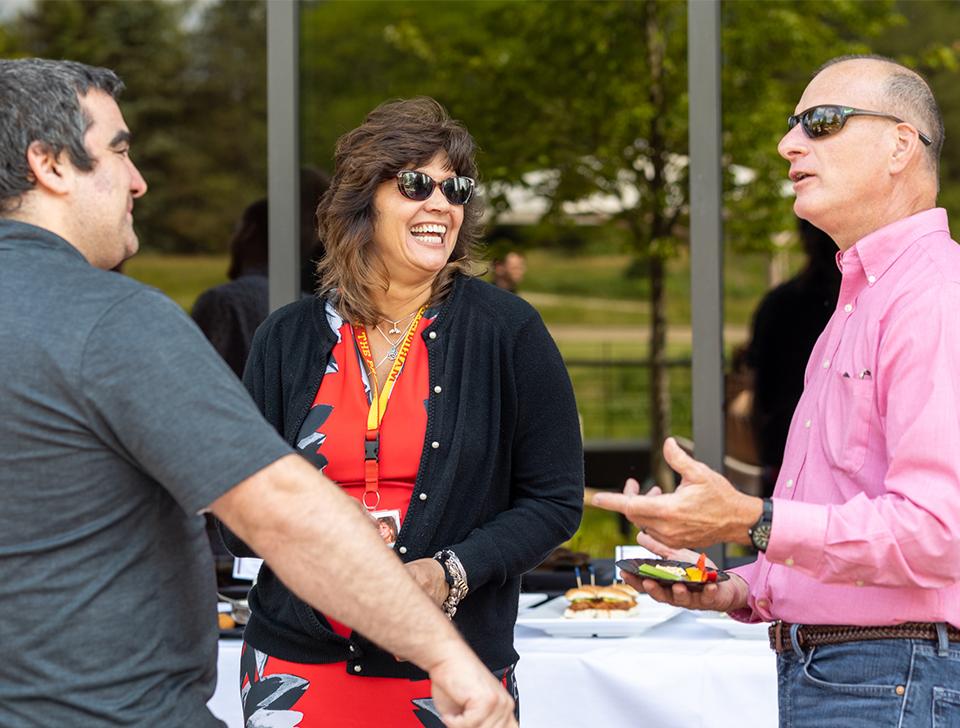 Three happy employees engaging with one another at work.