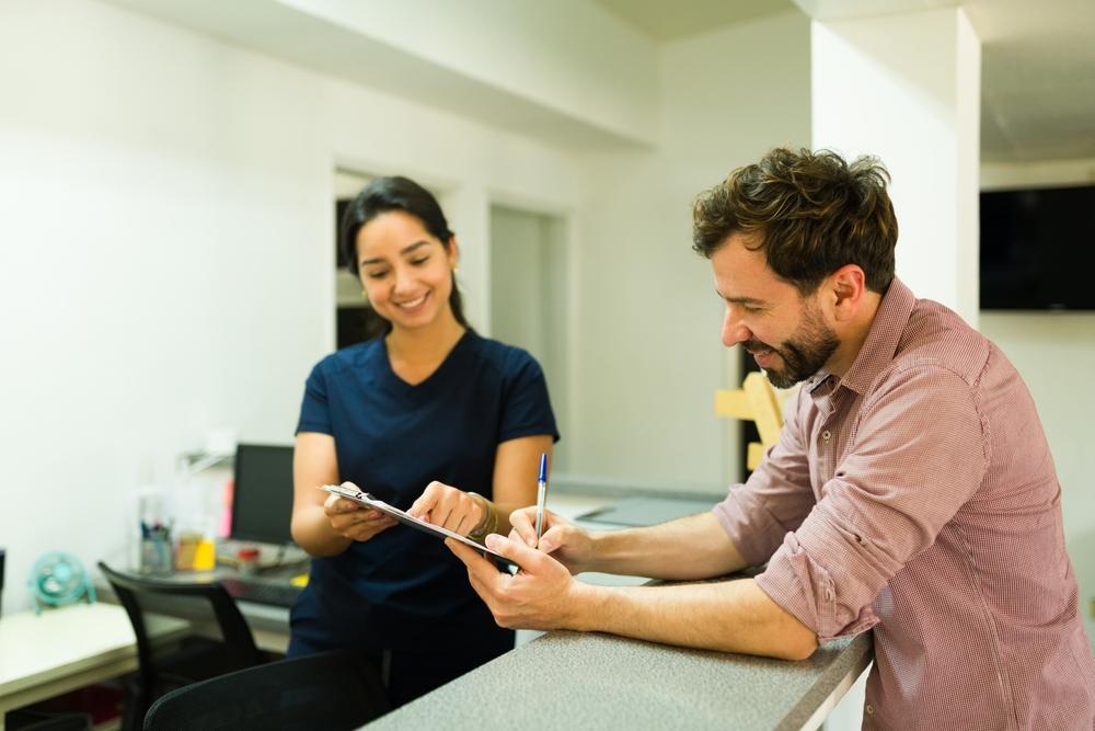 Man signing paper at dentist office