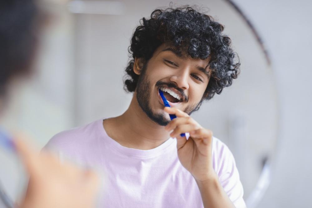 Happy man brushing teeth.