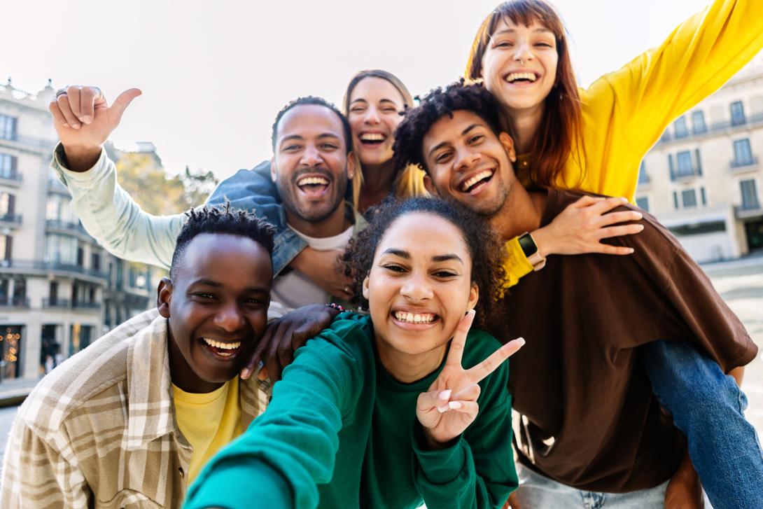 a group of young adults smile for a selfie photo
