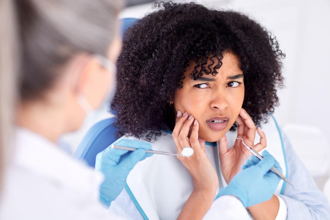 A woman holding her jaw in pain